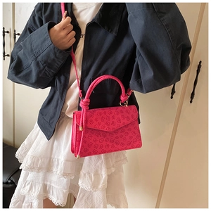 Borsa rosa shocking goffrata con trama floreale, chiusura a patta e manico annodato