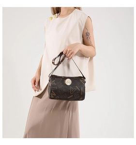 Close-up of retro cylinder bag with vintage lettering print and gold logo hardware