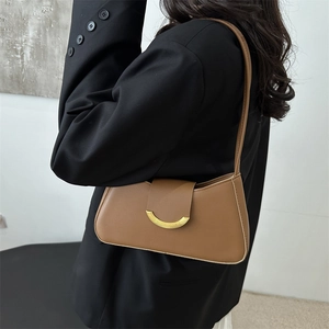 Chic brown leather underarm bag with gold crescent buckle for minimalist daily style