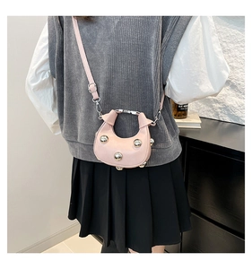 Détail du mini sac croissant rose avec clous sphériques argentés et poignée