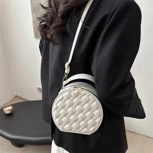 White woven circular crossbody handbag with gold zipper and adjustable shoulder strap