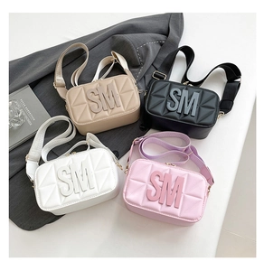 Detail van vier stijlvolle crossbody tassen met brede banden en SM-belettering