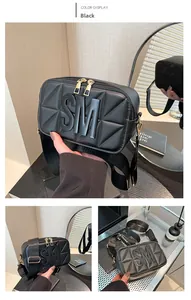 Detail van zwarte gewatteerde crossbodytas met lederen SM-initialen en brede weefband