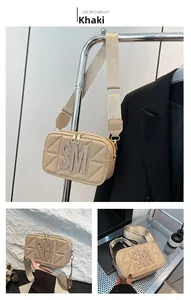 Detail van kaki gewatteerde crossbodytas met SM-logo en brede verstelbare schouderband
