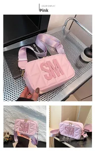 Roze gewatteerde crossbodytas met brede schouderband en SM-letterdetail close-up