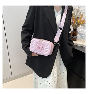 Detail van lichtpaarse gewatteerde crossbodytas met 3D SM-logo en brede riem