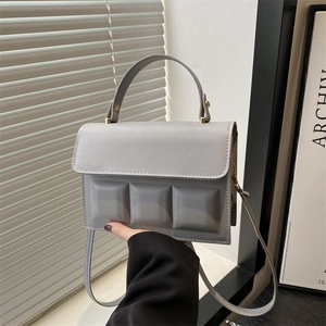 Detail of grey-blue square handbag with 3D geometric embossed squares and thick handle