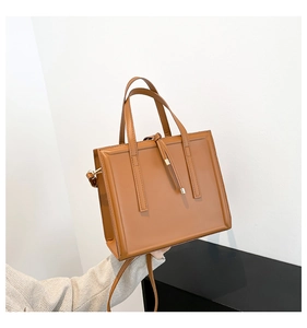 Detailed macro view of caramel brown tote bag featuring elegant stitching and drawstring detail
