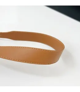 Dettaglio delle cuciture rinforzate e della texture della tracolla larga in pelle marrone