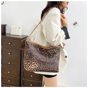 Dettaglio della borsa tote leopardata con cinturini in pelle marrone e texture morbida