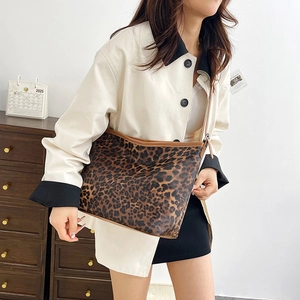 Dettaglio della borsa shopper leopardata con rifiniture marroni indossata a spalla