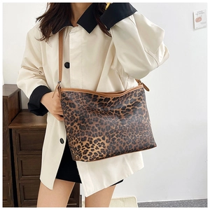 Dettaglio della borsa tote leopardata con finiture in pelle marrone e tracolla