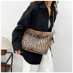 Dettaglio borsa leopardata con rifiniture in pelle marrone e chiusura lampo in metallo dorato