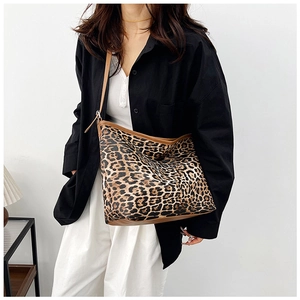 Dettaglio borsa shopper leopardata con finiture in pelle marrone e tracolle sottili