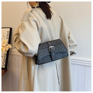 Dettaglio borsa vintage a catena con fibbia argento e texture con monogramma M