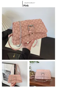 Detail view of pink crossbody bag with M-pattern print and silver chain strap