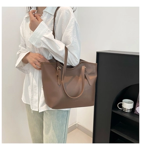 Detailed side view of a brown leather tote bag showing spacious capacity and shoulder strap