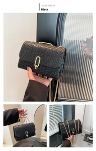 Detail view of woven black crossbody bag with gold chain strap and metal buckle clasp