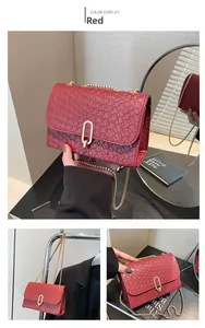 Macro detail of red woven shoulder bag with gold metal U-shaped buckle and chain strap