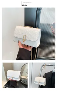 Detailed view of white crocodile pattern crossbody bag with gold chain and U-shaped lock