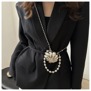 Chic silver shell-shaped mini bag with bead chain shown on black blazer suit
