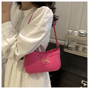 Gros plan détaillé d'un sac porté épaule rose orné d'un nœud doré élégant en métal