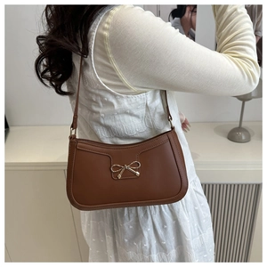 Vue détaillée du sac vintage en cuir marron avec boucle nœud portée par un mannequin