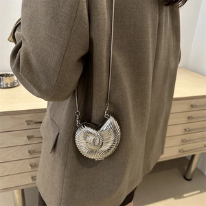 Silver metallic seashell mini crossbody bag with sleek spiral texture and snake chain