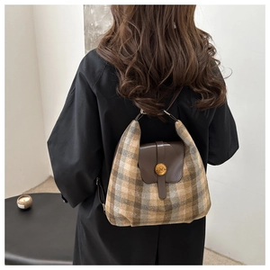 Detail of checkered shoulder bag with brown leather flap and round gold metal N buckle