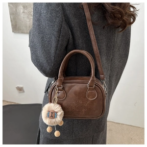 Detailed texture of brown leather tote bag with LUCKY OHIO SMALL embossed lettering