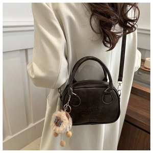 Detail der vintage kaffeebraunen Ledertasche mit lucky OHIO Prägung und Schaf-Anhänger