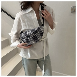 Detail of a black and white checkered corduroy saddle bag worn on a model in Japan style