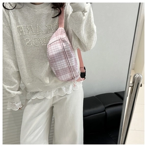 Detail der rosa-weiß karierten Segeltuch-Brusttasche mit verstellbarem Nylonriemen und Schnalle