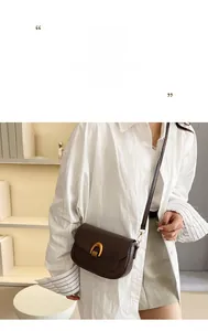 Detail of dark brown leather saddle bag featuring a vintage gold horseshoe buckle