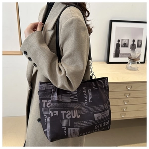 Dettaglio della borsa tote con stampa giornale vintage e catena d'argento sul modello
