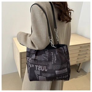Dettaglio della borsa tote vintage con stampa di giornale e tracolla in catena e pelle