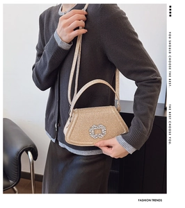 Sac à main champagne pailleté avec boucle en strass porté par un mannequin