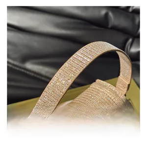 Détail de la poignée incrustée de strass dorés sur un sac de soirée élégant pour femmes