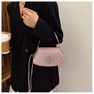 Sac à bandoulière rose pailleté avec boucle en cristal porté par un mannequin