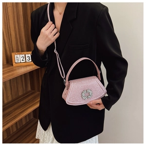 Detailed shot of pink glitter shoulder bag with sparkling rhinestone buckle and slim strap