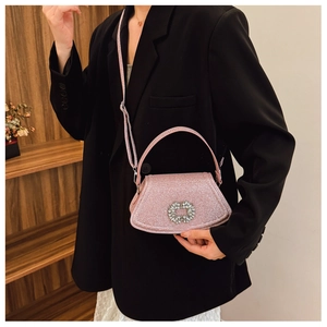 Close-up of pink glitter handbag with sparkling rhinestone buckle and thin shoulder strap