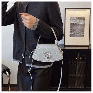 Détail du sac à main à paillettes argentées avec boucle en strass et bandoulière mince