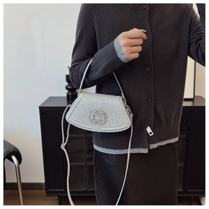 Détail du sac bandoulière argenté scintillant avec boucle cristal et finition métallique