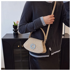 Detail of glitter fabric mini bag with large crystal buckle shown on a model