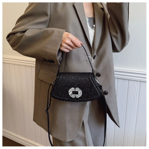Détail du sac à main noir à paillettes avec boucle en cristal et bandoulière réglable
