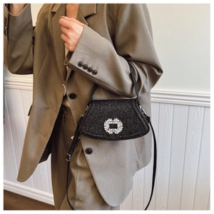 Detail of black glitter crossbody bag with square crystal buckle on olive blazer