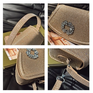 Detailed close-up of gold rhinestone evening bag with sparkling crystal buckle and metal chain