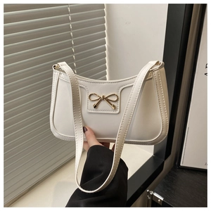 Close-up of white shoulder bag featuring a golden bow buckle and premium PU leather texture