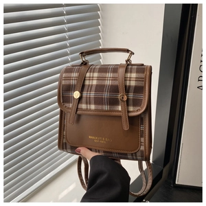 Details des braunen Vintage-Rucksacks mit Karomuster, Goldschnalle und Logo-Schriftzug