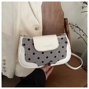 Détail du rabat en toile à pois et cuir blanc avec bandoulière en chaîne dorée